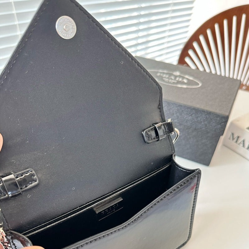 Clutch mit Dreieck-Plakette in Schwarz